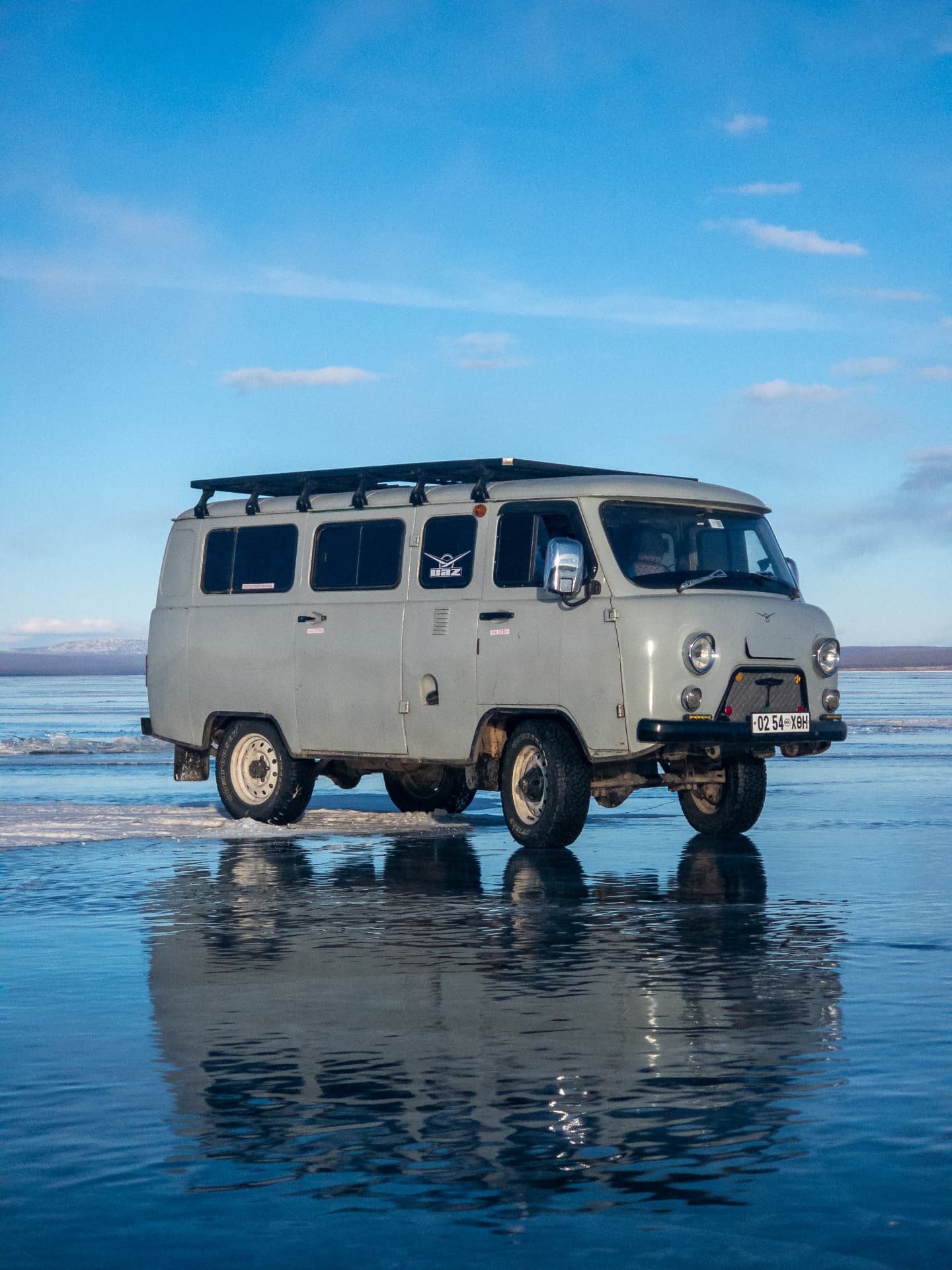 Mongolian van reflected on the surface of frozen Lake Khövsgöl